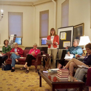 Group of woman seated listening to female speaker.