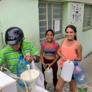 Two girls holding water jugs.