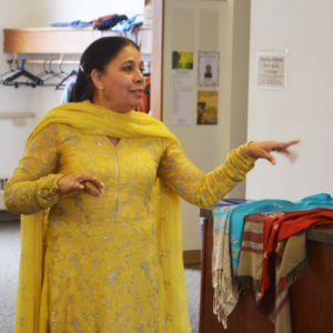 Lady wearing yellow dress with flowing scarf.